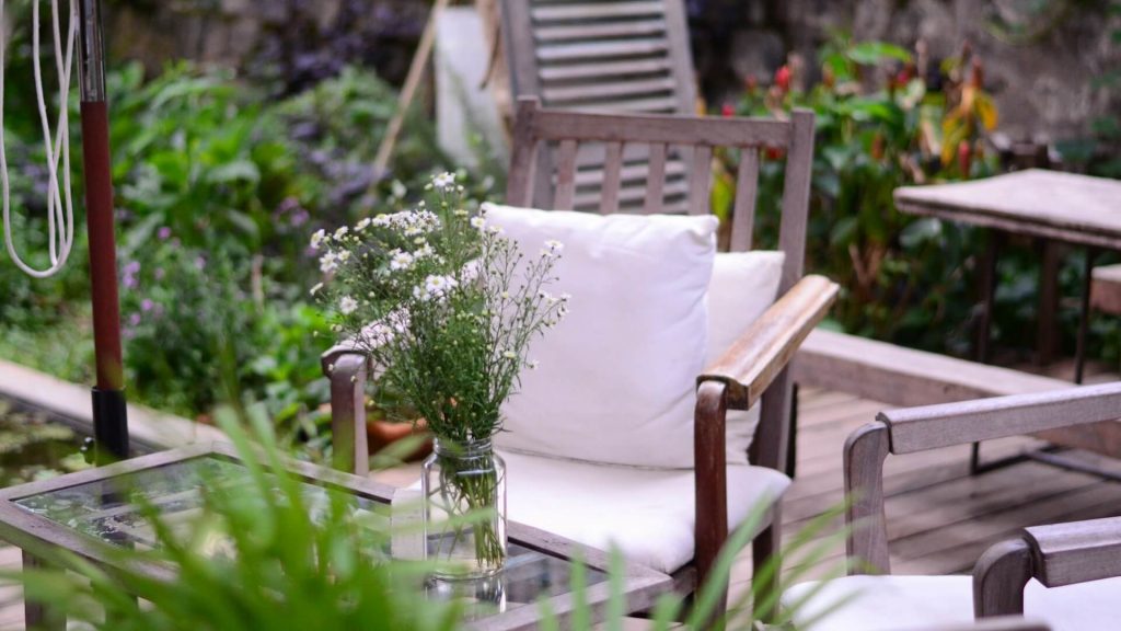 An outdoor space with a few personal touches, such as a vase used as a flower pot